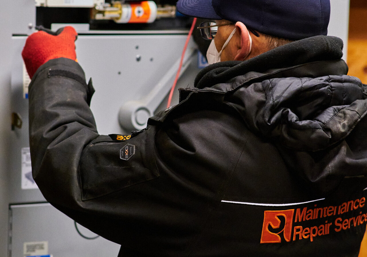 A certified Maintenance Repair Service electrician repairs a broken electric panel in a local commercial Toronto/Ottawa retail outlet store. 