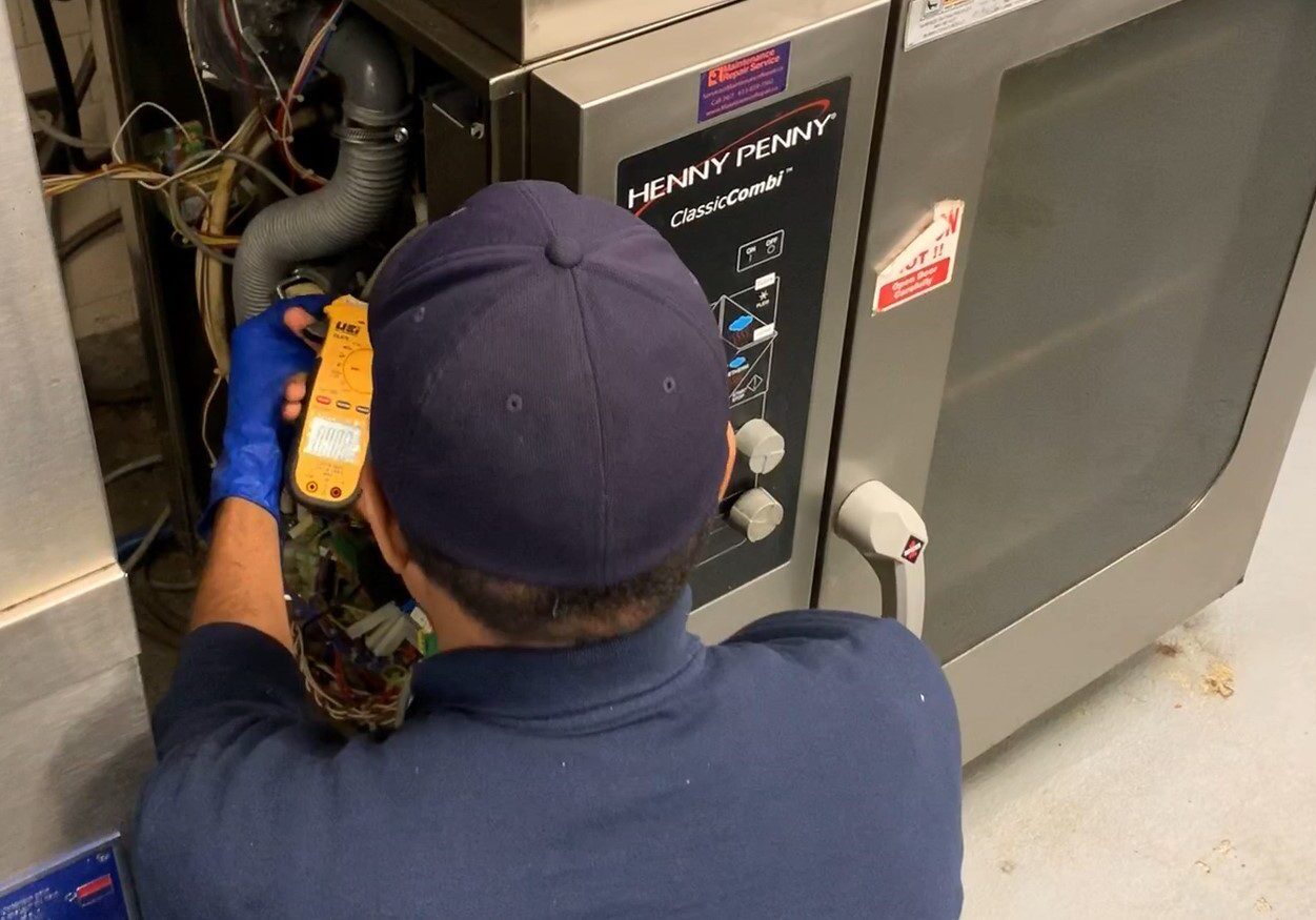 A certified Maintenance Repair Service mechanic repairs a broken Henny Penny combination oven for a local commercial Toronto/Ottawa retail outlet grocery store. 